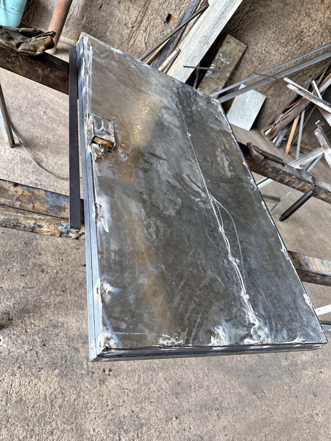 Detalhe da peça em fabricação, com chapa, estrutura de reforço e conjunto de fechamento.